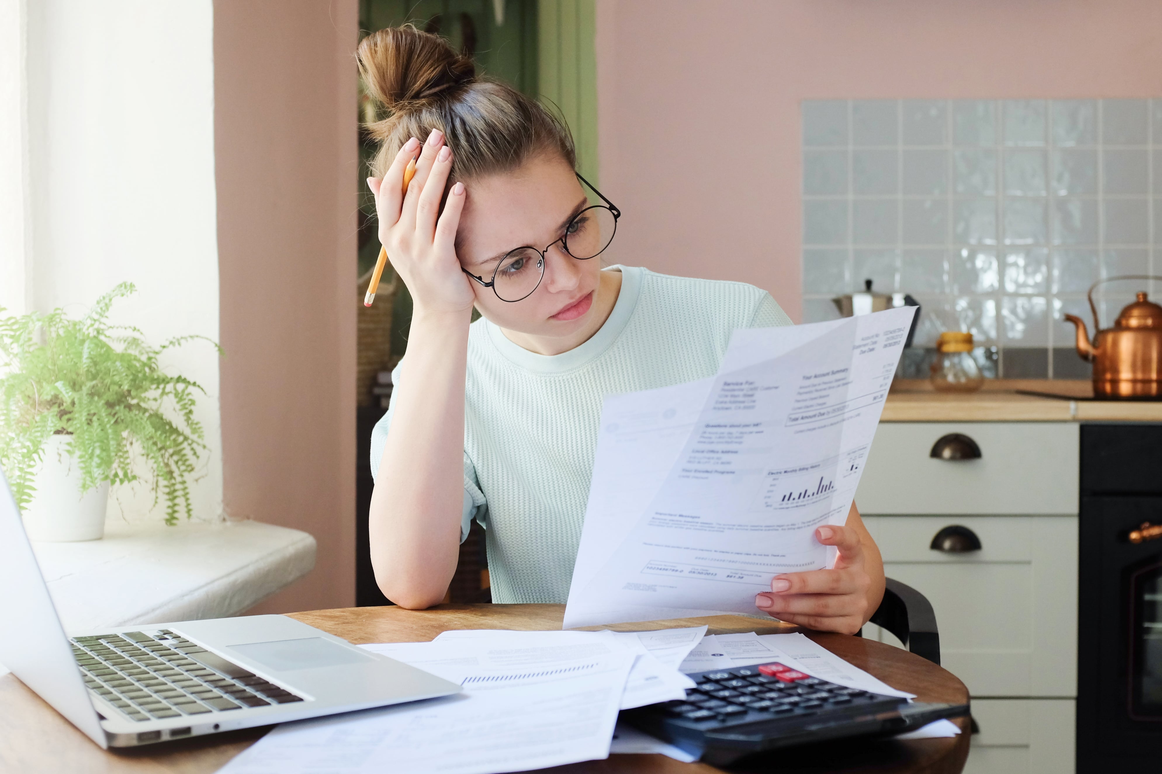 Young woman going through bills and considering debt consolidation.